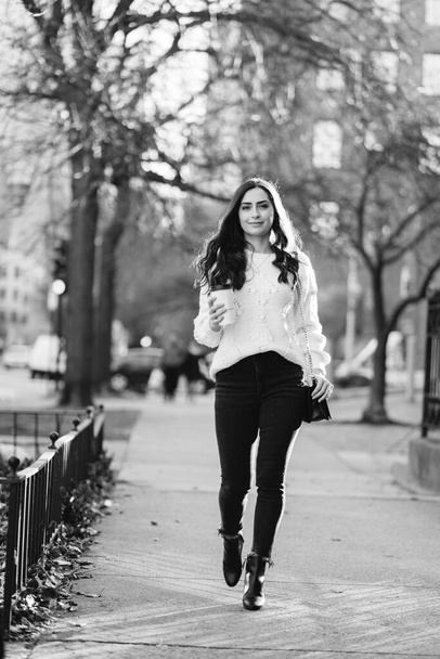 Cute brunette in a white sweater in a city - Foto, Imagem
