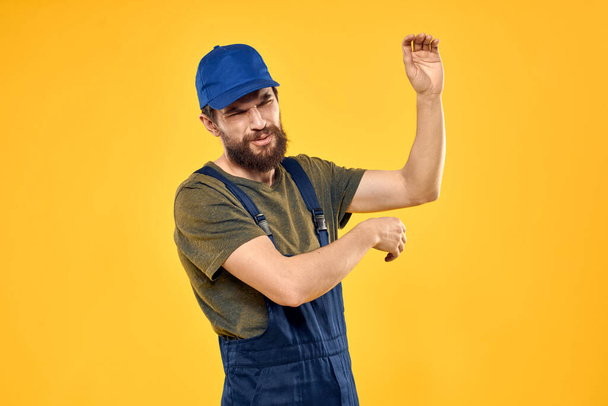 man in work uniform rendering service forklift work lifestyle yellow background - Zdjęcie, obraz