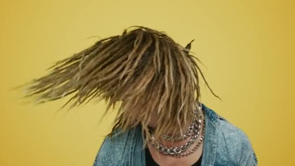 Rocker schwenken Kopf auf gelbem Hintergrund. Hipster bewegen Körper zur Musik - Filmmaterial, Video