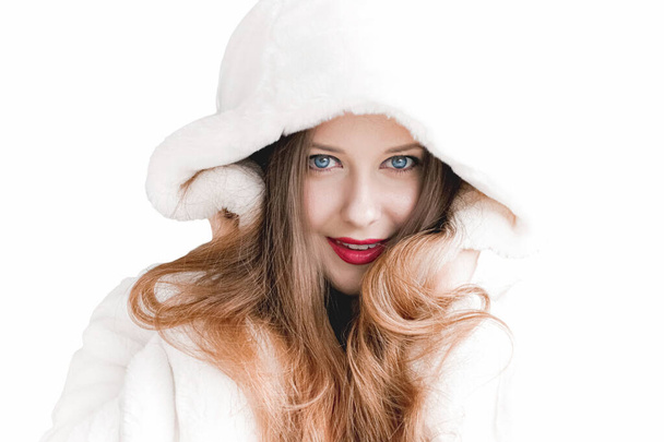 Young woman in fluffy fur coat with hood wrap, warm winter clothing for fashion and Christmas holidays - Photo, Image