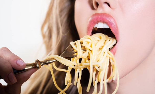 Close up sexy lips with noodles pasta. Female mouth eat spaghetti. - Foto, afbeelding