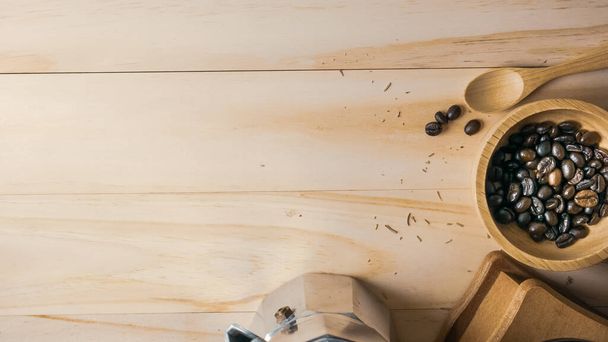 I chicchi di caffè in ciotola di legno vista dall'alto sul tavolo di legno per il contenuto alimentare. - Foto, immagini