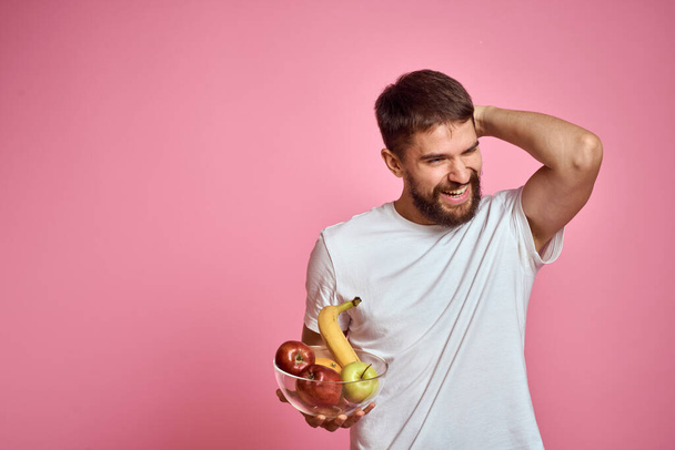 бородатий чоловік з бананом в руці на рожевому фоні модель веселих емоцій
 - Фото, зображення