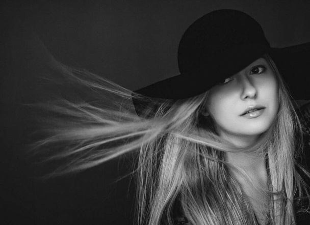 Mooie blonde vrouw draagt een hoed, artistieke film portret in zwart-wit voor mode campagne en schoonheid merk - Foto, afbeelding