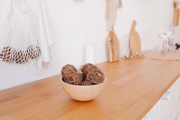 Das helle Interieur der Küche besteht aus natürlichen Öko-Komponenten. Bambusschale mit dekorativen Kugeln auf Holzarbeitsplatte des Küchensets - Foto, Bild