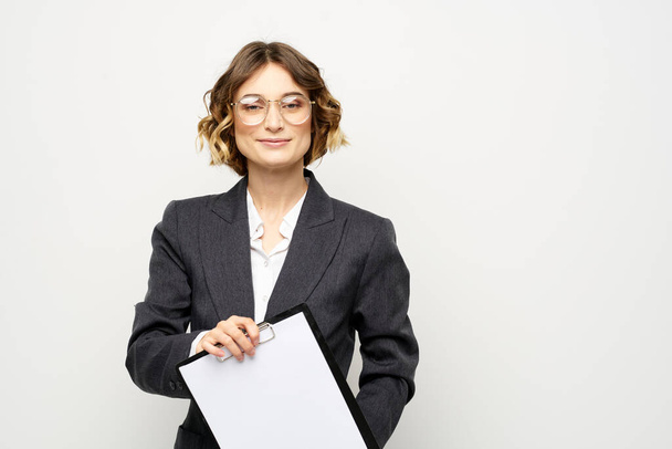 Επιχειρηματίας γυναίκα με ένα φάκελο των εγγράφων σε ένα ελαφρύ φόντο περικοπεί άποψη και κοστούμι πουκάμισο - Φωτογραφία, εικόνα