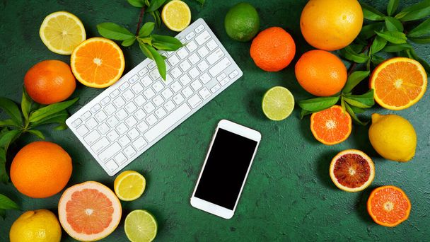 Citrus fruit on textured green background workspace blog hero header flat lay. - Foto, Bild