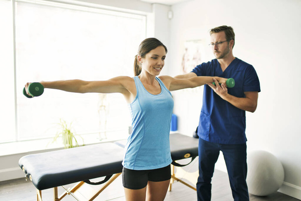 Male Physical Therapist Stretching a Female Patient Slowly. - Zdjęcie, obraz