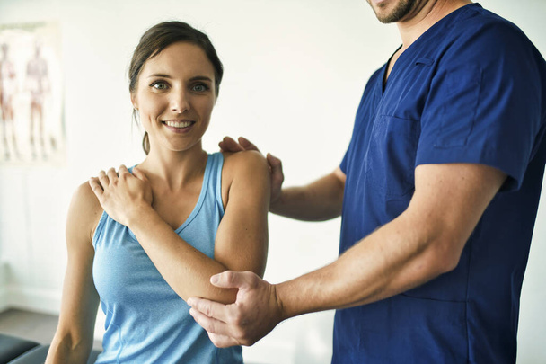 Male Physical Therapist Stretching a Female Patient Slowly. - Zdjęcie, obraz