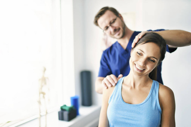 Male Physical Therapist Stretching a Female Patient nack - Photo, Image