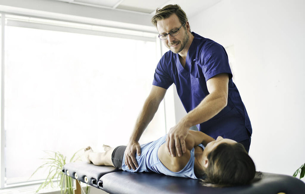 Male Physical Therapist Stretching a Female Patient Slowly. - Photo, image