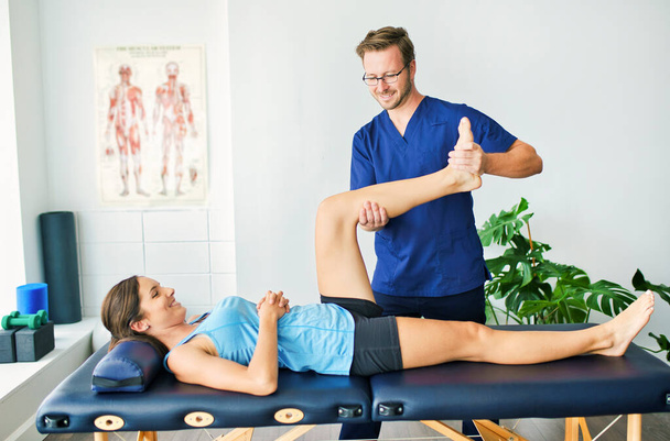 Male Physical Therapist Stretching a Female Patient - Photo, image