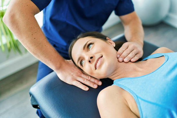 Male Physical Therapist Stretching a Female Patient neck - Fotó, kép