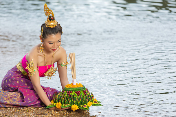 Азійська жінка в тайському вбранні традиційно тримає кратонг. Фестиваль Лой Кратонг - Фото, зображення