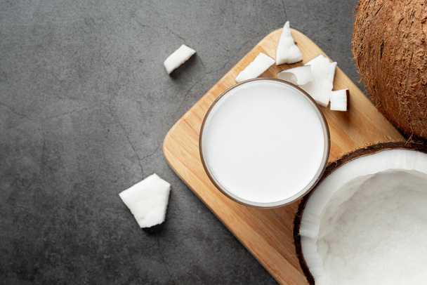 a glass of coconut milk put on wooden cutting board - Foto, afbeelding