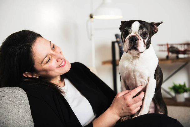 Woman with is Boston Terrier on the living room - Foto, Imagen