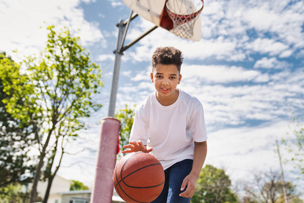 cute Afro american players playing basketball outdoors - 写真・画像