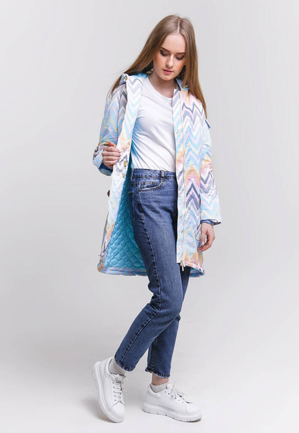 jovem mulher em uma jaqueta de outono em um fundo branco. conceito de foto de publicidade para loja. - Foto, Imagem