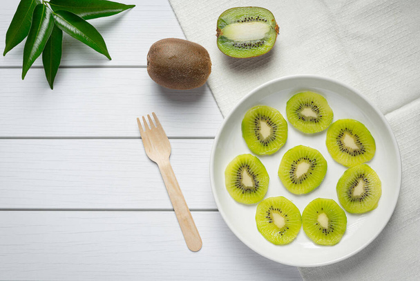 Fresh kiwi, slide into pieces, put on white plate - Photo, image