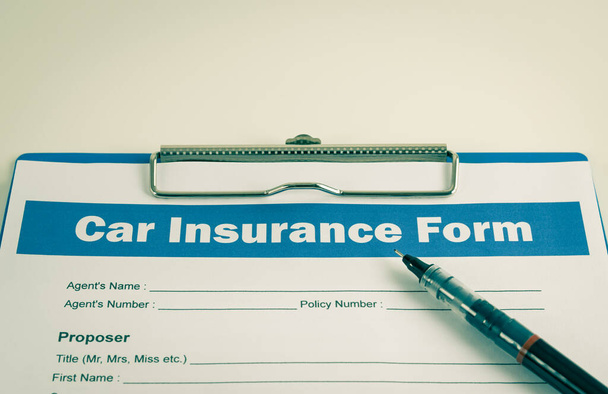 Car Insurance Claim Form or Auto Insurance Document és toll és vágólap fehér irodai asztal Vintage Tone - Fotó, kép