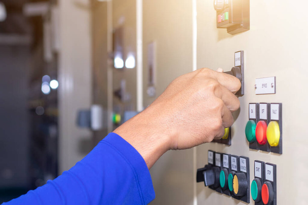 El modo de selección del interruptor de llave de mano de las personas en el panel de control eléctrico contiene botones de interruptor para operar máquinas industriales y equipos de fábrica en la industria - Foto, imagen
