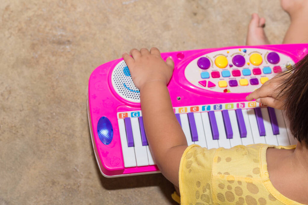 Pieni tyttö electone lelu opettavaisia pelejä kotona, Electone lautapelejä lapsille modernin oppimisen, Tyttö oppia ääni sävy musi - Valokuva, kuva