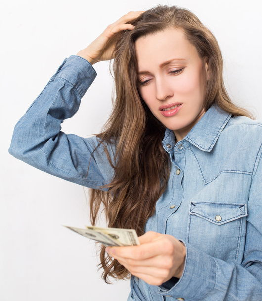 Stressed young woman holding money - Фото, изображение