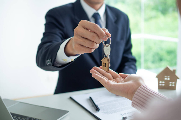 従業員は住宅ローンや購入のために顧客に家の鍵を与えた。不動産仲介業者と顧客住宅ローン契約の話し合い - 写真・画像