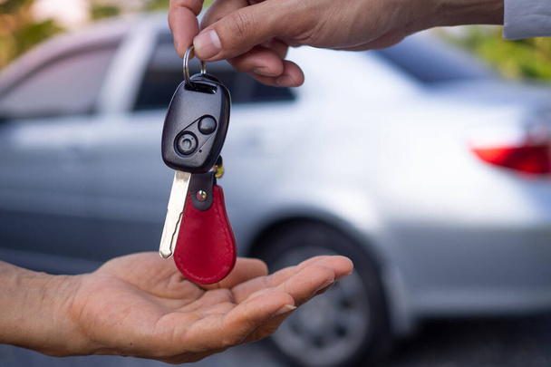 Der Autoverkäufer und der Schlüssel zum neuen Besitzer.    - Foto, Bild