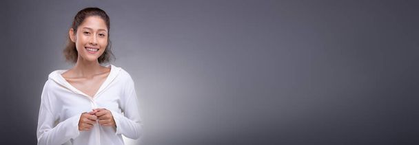 Retrato de moda 20s mujer asiática tiene cara hermosa, ella usa ropa de camisa blanca, feliz sensación alegre expresión sobre gris fondo aislado espacio de copia pancarta - Foto, Imagen