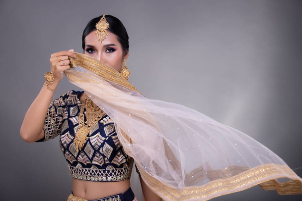 Ojos de belleza india con perfecta maquillaje novia de boda, Retrato de una hermosa mujer en traje de novia pakistaní étnico tradicional con joyas pesadas, espacio de copia de pancarta de fondo gris - Foto, imagen