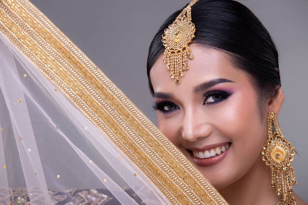 Olhos de beleza indianos com perfeito compõem noiva de casamento, retrato de uma mulher bonita em traje de noiva tradicional paquistanês étnico com jóias pesadas, espaço de cópia banner fundo cinza - Foto, Imagem