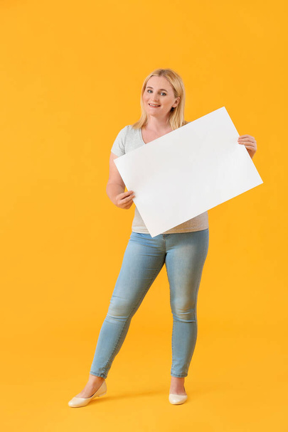 Woman with blank paper sheet on color background - 写真・画像