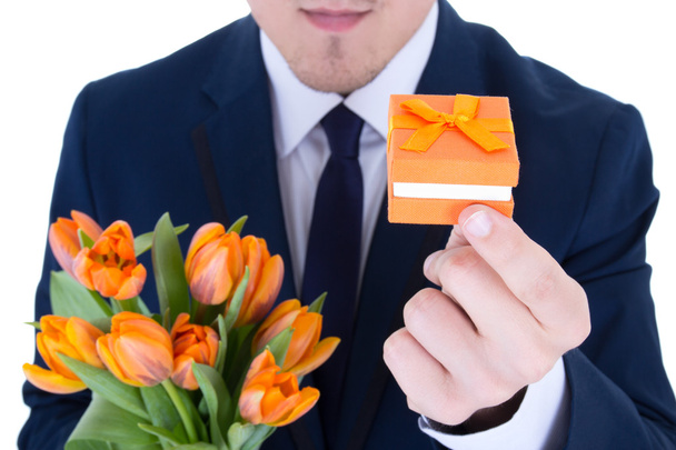 человек, держащий Подарочная коробка с обручальное кольцо и цветы, изолированные на w - Фото, изображение