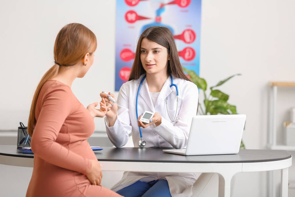 Pregnant diabetic woman visiting doctor in clinic - Фото, зображення