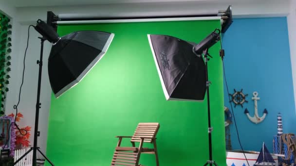 Altı köşeli stüdyo ışıkları olan fotoğraf ya da video stüdyosu. Yeşil ekran ve sabit sandalye - Video, Çekim