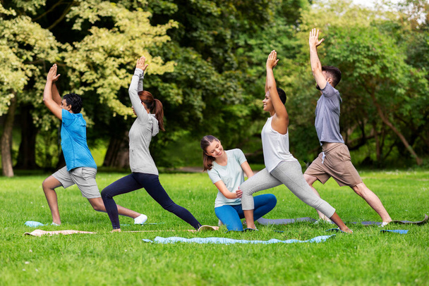 group of people doing yoga at summer park - Фото, изображение