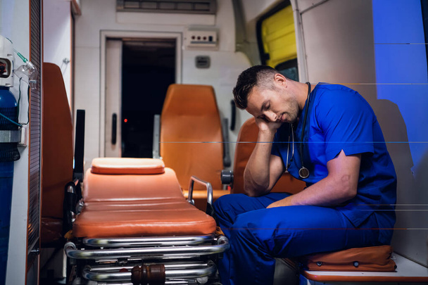 Виснажений парамедик спить у машині швидкої допомоги
 - Фото, зображення