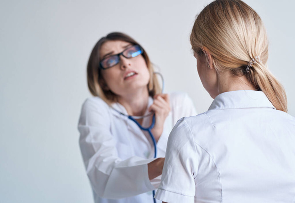 ammatillinen nainen lääkäri lääkärin puku ja lasit sininen stetoskooppi potilas - Valokuva, kuva