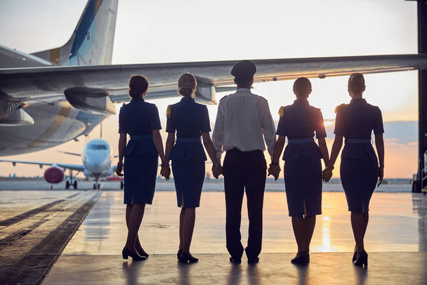 Дружелюбные люди авиационной промышленности, смотрящие в небо - Фото, изображение