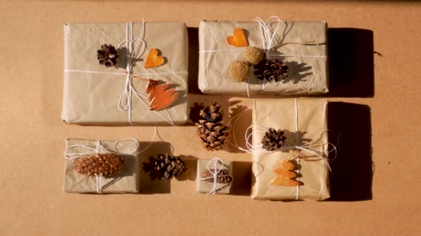 Zero waste Christmas knolling flat lay with hard shadows. Hand crafted eco gift, natural New Year jute decorations top view. Kraft paper wrapping without plastic concept. Orange zest trees, hearts and cones 4K video - Footage, Video