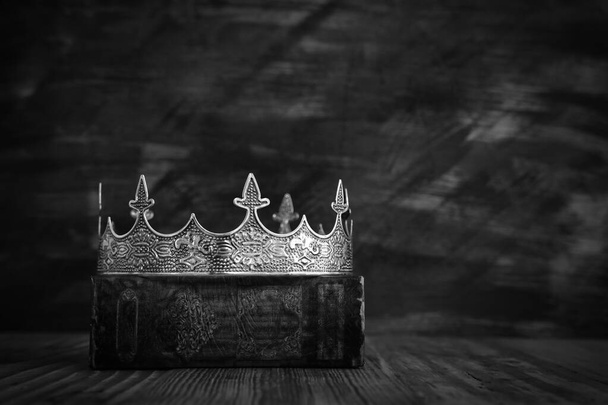 low key image of beautiful queen/king crown on old book. vintage filtered. fantasy medieval period. black and white - Foto, immagini