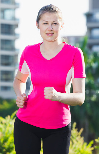 Young girl in pink T-shirt is jogging - Foto, Bild