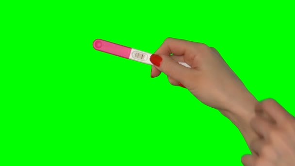 Nainen osoittaa sormella kahta punaista raitaa positiivisessa raskaustestissä. 4K - Materiaali, video