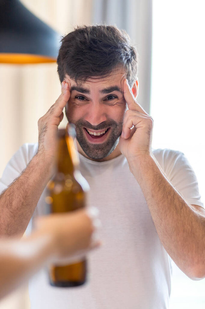 Photo of bearded man looking at beer on white background. - Foto, imagen