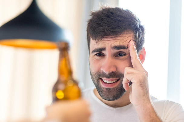Photo of bearded man looking at beer on white background. - Foto, Bild