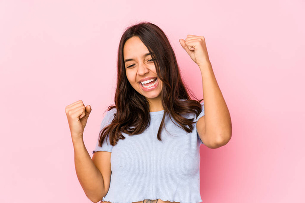 Young mixed race hispanic woman isolated celebrating a special day, jumps and raise arms with energy. - Photo, Image
