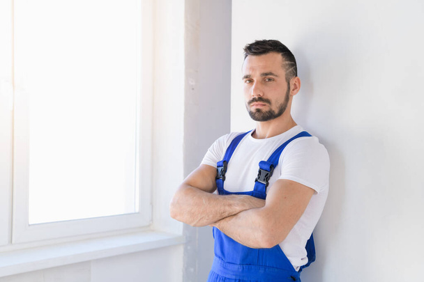 Man in blue overalls folded his arms over his chest - Fotografie, Obrázek