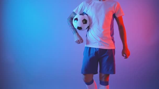 Unerkennbarer Fußballer posiert selbstbewusst mit Ball im Innenraum, vereinzelter Schuss - Filmmaterial, Video