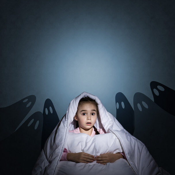 girl under the covers with a flashlight - Zdjęcie, obraz